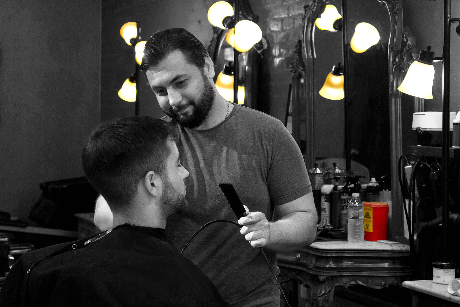 A man getting his hair cut by another man.